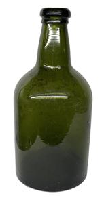 K288 Early Green Glass Wine Bottle featuring bubbled glass, a kicked-in bottom, and an applied rim. Approximate Measurements:  3 7/8 diameter x 8 ¼ tall.   