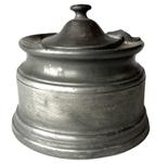 K188 18th century Pewter inkwell fitted with four quill holes and hinged lid covering its original removeable porcelain ink pot.  Circa 1780s  1800. Measurements: 4 1/8 diameter x 3 ½ tall to top of finial on lid. 