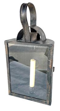 K121 19th century half-moon shaped tin and glass Hunting / Barn lantern featuring a prominent glass panel in front with a hinged door in back that opens easily for access to the interior candle socket. The top features double hoods to protect the internal candle flame from wind/rain. A sturdy shaped tin handle with rolled edges remains intact on top for carrying / hanging purposes. An evenly spaced, pierced circular pattern that serves as a source for airflow adorns the top edge of the back rounded side of the lantern. Lantern retains its original black painted surface. (Candle not included). Measurements: 7 5/8 wide across front glass panel x 4 ½ deep x 15 ½ tall to top of handle. 