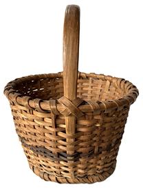 K181 Eastern Shore, Maryland hand woven footed Oak Splint Basket featuring tapered sides resting on single wrapped, steamed and bent footed base. The tall, sturdy, steamed and bent handle is woven into the sides and is secured with tiny tacks into the single wrapped, double rim that matches the footed base. Great natural patina surface with a decorative band of darker woven splints encircling the center of the sides and in the center of the bottom. Measurements: 10 ¾ x 11 ½ diameter across top x 7 tall sides x ~13 tall with handle. The footed base is ~8 ¼ diameter.   