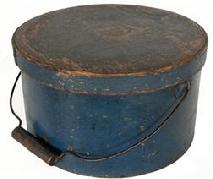 **SOLD** J199 Exceptional early 19th century New England bail handle pantry box retaining original blue painted surface. Lid impressed "HOLMAN, HEYWOOD & CO MANUF'S, FITZWILLIAM DEPOT, N.H." Heavy construction with overlapping steamed and bentwood sides secured by small copper tacks.