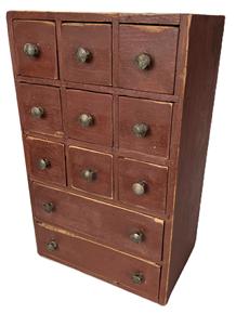 **SOLD** K1730 Late 18th century Lancaster County Pennsylvania original red painted Apothecary / Spice Box with 11 drawers. Workmanship abounds with blind-dovetailed case and mortised drawer stretchers that support the nine-over-two configuration of drawers. Each drawer is mortised and tiny T nail construction with chamfered drawer bottoms. The wood is pine. Circa 1780s  1800. Measurements: 10 ¾ wide x 7 ¼ deep x 17 ¼ tall.   