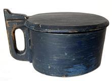 H1053 Original blue painted Tankard style treenware lidded box  featuring steamed and bentwood sides secured with woven reeds and tacks. Wooden handle. Chamfered edge around lid. Lid opens to reveal a clean, natural patina interior. Measurements: 9 ½ x 7 ½ x 5 3/8 tall.