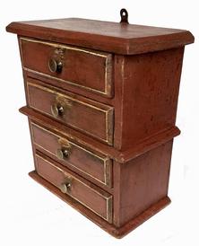 J262 Small hanging stack of drawers bearing early red painted surface with pinstriping on drawer fronts. Drawers are dovetailed. Combination of T and wire nail construction. Great wear. Measurements: 10 ¾ wide x 5 ½ deep x 11 ¾ tall 