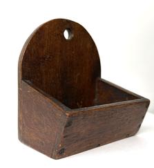 RM1541 Diminutive Pennsylvania Wall Box featuring canted sides and a tombstone shaped back with a hole for hanging.  The wood is walnut and retains its original old finish. Square head nail and early screw construction. Circa 1840s. Measurements: 3 ¾ wide x 2 ½ deep x 4 tall (Back) x 1 ¼ tall (front)