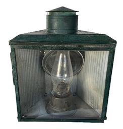 F106 19th century large glass and tin Lantern with smoke ventilator chimney, large round reflector and clear glass hinged door for access to the fuel chamber inside. Lantern bears multiple layers of old green paint.  Original metal bracket remains intact on back for mounting to a wall or post.  Measurements: 15 wide x 9 deep x ~18 ¼ tall.  