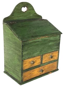 K261 Late 18th century Pennsylvania Wall Box in the original green and yellow paint with slanted lift lid over three dovetailed drawers with brass pulls and beaded edge drawer fronts. Heart shaped cutout at top for decorative / hanging purposes. Divided interior. Dovetailed case. T and square head nail construction. Circa 1790  1810. From a Pennsylvania private collection. Measurements: 10 5/8 wide x 6 ½ deep x 14 ¼ tall.  