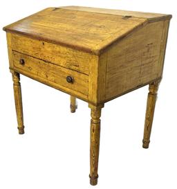 RM1544 Early 19th century East Berlin, Pennsylvania Schoolmaster's Desk over one dovetailed drawer resting on turned legs bearing original yellow painted surface. The hinged, slanted lift lid opens to reveal a clean, natural patina interior featuring a center configuration of two small, dovetailed drawers over one pigeonhole with mortised drawer stretchers. The case and legs are fully mortised and pegged construction. The wood is pine. Circa 1830s. Measurements: 35 ¼ wide x 25 ¾ deep x 37 ¼ tall (back) x 33 tall (front). 21 ½ clearance from apron to floor.  