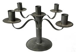 RM1495 Early solid tin round candelabra featuring four delicately curved, rolled edged arms extending from a center post. There are a total of five candle cups  each with nicely rolled edges soldered to a drip cup that features a singular crimped edge that matches the base. All soldered joints are secure.  Approximate measurements: 5 ½ diameter base x 8 tall x ~14 across