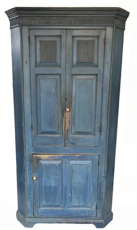 **SOLD** J256 Exquisite early 19th century New England original soldier blue painted corner cupboard boasting spectacular reeded detailing, cornice molding, applied bracket base and raised panel doors. Applied molding accents adorn the front corners and around each of the doors. Two doors over one door configuration, with all doors being fully mortised and wooden pegged. The upper doors open to reveal a red painted interior with three shelves, each bearing plate grooves for storage and display purposes. The bottom door opens to reveal a red painted interior with one shelf.  The entire cupboard is wooden pegged construction, with molded accents being attached with tiny square head nails. From the Estate of St. Mark, Newtown, Connecticut. Measurements: 82 tall and takes a 29 corner (at top)