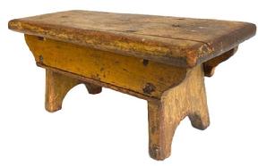 K1610 19th century Pennsylvania original mustard painted footstool boasting half-moon cut out feet and double drop aprons bearing shaped ends and a beaded edge. Top bears rounded edges on all sides. The wood is pine  with square head nail and early screw construction. Very sturdy. Circa 1850s. Measurements: 14 long x 5 ¾ wide x 6 ¼ tall.    