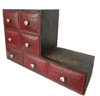 **SOLD** K1713 Late 19th century American original painted countertop Spice Cupboard / Apothecary  The wooden case bears original black painted surface and houses 7 rolled tin drawers with original red painted and decorated drawer fronts and original white porcelain knobs. The top four drawers bear remnants of hand painted advertising that reads:  10 Lbs Net   Globe Mills Standard PEPPER, CINNAMON, CLOVES, GINGER. There are also remnants of advertising on bottom three drawers, however they are illegible. Globe Mills (Flours / Spices / Feed) was in business in Fort Wayne, Indiana from approximately 1888 to 1921. This style of spice cabinet was used in the late 1880s  1900 as a countertop display in a general store. Overall measurements: 29 wide (17 wide on taller end) x 10 ¼ deep x 19 ¼ tall (6 tall on end).  