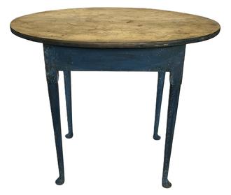 K1508 Early 18th century Connecticut Tea Table bearing early old blue painted surface with scrubbed top. Table features overhanging oval top with graceful Queen Anne legs ending in pad feet. The wood is cherry. Wooden peg and square head nail construction. Circa 1740s. Measurements: 33 ¾ wide x 23 ½ deep (oval top) x 26 ¾ tall. 