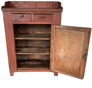 H234 Early 19th century Pennsylvania Jelly Cupboard, in the original red paint, dovetailed case  with two dovetailed drawers over  a single panel door, with a nice high cut out foot, and applied gallery, Nice and clean interior, original knobs. Measurements are: 51 ½ tall x 37 wide x 19 ½ deep