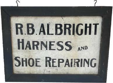 J204 Early Pennsylvania double-sided trade sign advertising R. B. ALBRIGHT HARNESS AND SHOE REPAIRING hand painted in black letters on a white painted background. Wear to the paint in the advertising area is indicative of age. The sign is painted on tin and is encased in a wooden frame. Both sides of the sign are in good condition. Unsigned. Overall measurements: 42 wide x 1 ¾ thick x 30 ¼ tall. The frame is 3 ½ wide. Tin sign area measures 35 wide x 23 ¼ tall. 