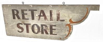 J219 Late 19th century wooden Trade Sign advertising "Retail Store". This single-sided sign boasts brown painted letters on a white background with orange scroll paintwork along the scalloped cut out end. One board. Original iron eye hook hangers remain intact on the top edge. Measurements: 30 wide x ¾ deep x 11 3/8 tall