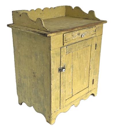 K158 19th century Pennsylvania original yellow painted Wash Stand with one drawer over one door configuration with an applied scalloped gallery on top resting on a decoratively cut out apron / ends. Square head nail construction with dovetailed gallery and mortised panel door. Clean, natural patina interior with shelves for additional storage. The wood is pine. Circa 1860s-1870s.  Measurements: 28 wide x 18 deep x 32 ½ tall (back, with gallery) x 28 ½ tall (front).  