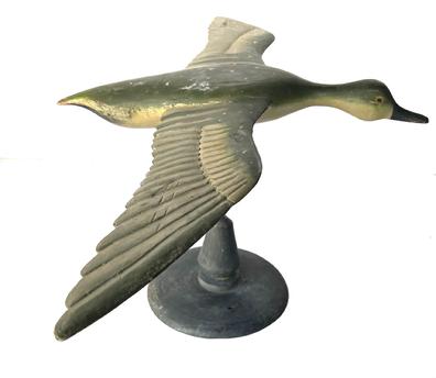 J230 Full sized Flying Duck Decoy with very detailed carved wings and nice dry, original painted surface. Carver unknown. Mounted on a wooden base for display purposes. Measurements: 31 ½ wingspan x 18 ½ beak to tail. The base is 8 ¾ diameter. Overall mounted height is 13 ½ tall.