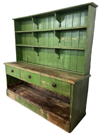 K1514 Very unique Pewter Cupboard in old green paint over mustard paint  with open top boasting shelves secured with decorative shelf supports. Each shelf bears attached molded plate stops. The bottom section boasts three dovetailed drawers over an open storage area that bears extensive wear. Circa 1850s. Found in Pennsylvania. The wood is white pine. Measurements: 68 ½ wide x 19 deep x 65 ½ tall. 