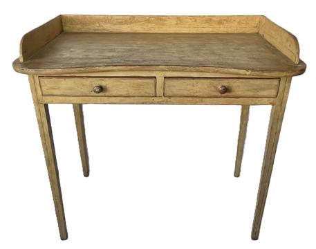 K1810 19th century Pennsylvania original mustard painted pine table with two drawers and shaped top with gallery resting on tall, delicately tapered Hepplewhite legs. Painted surface retains remnants of original black pinstripe decoration throughout. Square head nail construction with apron being fully mortised into the legs. Measurements: 37 ¼ wide x 21 deep x 33 ½ tall (back) x 30 ¾ tall (front). Apron to floor is 25.  