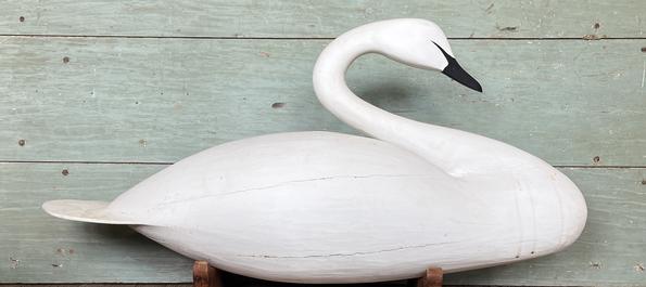 K1559 Full Size Swan Decoy bearing original hand painted surface. Gracefully carved in a natural swimming pose with a unique paddle shaped tail. Unknown carver. Custom base included for display purposes. Approximate measurements:  ~42 ½ long x ~11 wide x ~18 ½ tall. (~22 ½ tall on stand) 