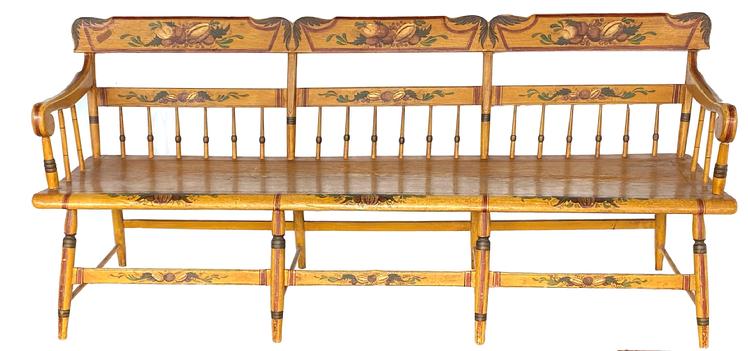 Paintted, Pennsylvania, plank-seat settee of the mid-19th century (1845-65), in the half-spindle-back style with an angel wing crest rail. The mustard yellow with yellow, brown and black striping. The theorem-like registers on the crest rails are typical of rural Pennsylvania chairs and benches. There is a large bell flower in the center, flanked by a tulip and various flora. On each side register there are grapes, flanked by another bell flower and more foliage. The overall result is a pleasing example of Pennsylvania German Folk Art on a piece of rural-made, paint- decorated furniture.  Condition: Minimal, expected wear. Excellent, original surface.