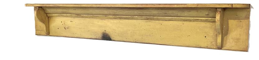 **SOLD** K1724A 19th century Pennsylvania hanging wall shelf retaining beautiful original mustard yellow painted surface.  Shelf features cookie cut corners and shaped supports with applied molding between the supports. A beaded edge adorns the entire bottom edge of the shelf.  Square head nail construction. The wood is pine. Circa 1850-1860s. Measurements: 83 wide x 8 deep x 13 ¼ tall.  