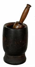 H952C 19th century turned wooden Mortar and Pestle in original black painted surface.  Nicely turned shape with simple incised ring around the outside and a molded interior lip surrounding the opening of the Mortar. Natural patina interior. Several visible surface cracks from age and shrinkage, however none go all the way through. The pestle retains natural patina finish. Measurements: 4 3/4" diameter x 7 3/4" tall. Pestle is 9� long. 