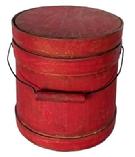 **SOLD** L498 Small 19th century Shaker firkin bearing original dry, red painted surface. Thick walled staved and bentwood construction with wire bail swing handle with wooden handle grip that is secured to the firkin with diamond shaped bail plates. Overlapping finger on all three wooden bands are secured with small copper tacks. Natural patina interior. Measurements: 6 3/8� diameter (Bottom) x 5 7/8� diameter (top) x 6 &frac12;� tall. 