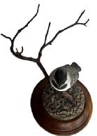 M292 Lifelike Folk Art carving of a baby Black-capped Chickadee perched upon a branch � signed and dated �Rosalyn Leach Daisey 1989� on bottom. All wooden, hand carved and painted, with exceptional details. Rosalyn Leach Daisey (b. 1945) transitioned from a registered nurse into a renowned Delaware-based woodcarver. Approximate overall measurements: 4 &frac34;� diameter bottom x ~8� across widest point x ~5� tall at tallest point.