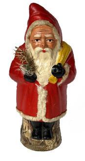 L481 Early 20th century Belsnickel holding a feather tree with a yellow pack hung over his shoulder. Papier Mache construction. Approximate measurements: 2 &frac34;�-3� diameter x 9 &frac12;� tall.