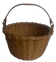 RM1648 Hand woven Swing Handle natural basket - signed "NEWT WASHBURN" on bottom. Tightly woven with double wrapped, double rimmed top with steamed and bent, notched handles that are woven into the sides to secure the swing handle to the basket. Ever so slightly bumped up bottom for weight distribution and added air flow. Excellent condition. Measurements: 8 &frac34;� x 9� top diameter x 5 &frac34;� bottom diameter. The sides are 5� tall and overall height with handle is ~9 &frac12;� tall. Newt Washburn (b. 1915) of Vermont is from a well-known line of New England basket makers � whose work is highly sought after.