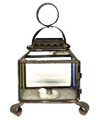 M226 Small sized late 19th century tin candle lantern featuring colorful red, blue green and yellow stained-glass panels and one etched pattern panel. Handmade curled tin feet and a distinctive circular handle atop the decorative hooded top. Singular small sized candle socket inside. Cracks to two panels as seen in photos. Measurements: 7 &frac34;� x 5 &frac14;� across feet. Overall height, including ring is ~10 &frac12;� tall.  