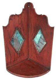 **SOLD** RM1626 Mid-19th century Pennsylvania hanging corner candle shelf retaining its original red painted surface. Shelf features two diamond shaped mirror inserts to reflect the candlelight and a decorative cut out top with hole for hanging. Tiny square head and wire nail construction. Circa 1850s. Measurements: 8 &frac12;� deep x 17" tall.  Each of the diamond shaped areas measures 7 &frac12;� wide x 5 &frac12;� tall.