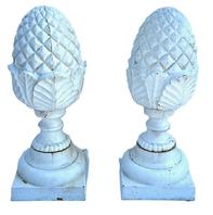 M156 Very early 20th century pair of matching solid cast iron Pineapple finials with geometric diamond shaped details on top and a series of detailed curved leaves and shaped rings below � resting on square bases. Surface retains several layers of old white paint. Extremely heavy.  Circa 1900-1920s. Approximate measurements: Bases are 8� square x ~20 &frac34;� tall.  