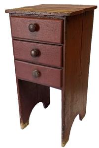 M147 Mid-19th century Pennsylvania three drawer stand featuring dovetailed drawers and half-moon cut out feet in original red painted surface. Unusual configuration. The wood is walnut on the drawer fronts and sides, with secondary wood being white pine. Square head nail construction with mortised/dovetailed drawer stretchers. Circa 1850s. Measurements: 17 &frac12;� wide x 18� deep x 36 &frac34;� tall. Clearance from bottom drawer to floor is 18 &frac14;�.  