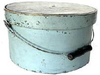J413 19th century Pennsylvania bail handle Pantry Box with lid. Light blue painted surface over the original darker blue paint. Steamed and over lapping bentwood sides are secured with small metal tacks. The sides of the pantry box are fitted with a pair of metal handle mounts securing an arched wire swing handle with wooden hand grip. Heavy construction with tightly fitting lid. Measurements: 11 &frac34;� diameter (top) x 11 &frac12;� diameter (bottom) x 6 &frac14;� tall