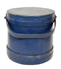 M1134 Pennsylvania lidded wooden Firkin in the original dry blue painted surface, featuring tongue and groove softwood staved sides, overlapping joint wooden bands secured with small tacks and steamed and bent wood handle with wood peg attachments. Clean, natural patina interior. Found in Pennsylvania. Measurements: 11 &frac14;� top diameter x 12 1/8� bottom diameter x 11 &frac14;� tall. 