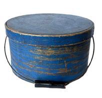 **SOLD** L246 19th century New England Bail Handle Pantry Box with the original old dry dark blue painted surface. The overlapping bentwood sides are secured with small metal tacks. The sides of the Box are fitted with a pair of oval stamped tin handle mounts that secure an arched wire swing handle with wooden hand grip bearing black painted surface. Natural patina interior. Measurements: 11 &frac12;� diameter x 6 3/8� tall.