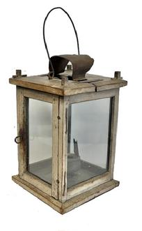 M269 Very rare and unusual, late 19th century Pennsylvania wooden Lantern featuring four glass panels contained within a wooden post and pinned construction frame boasting old oyster white painted surface.  Tiny wire loop hinges allow the door to open freely for access to the crudely made circular sheet iron grease/oil lamp rather than a regular candle socket. The grease/oil lamp has its original wick support and hinged lid still intact. There is a hole in the top for ventilation purposes which is covered on the exterior with a bent piece of sheet metal to create a hood that protects the candle flame from wind/rain. There are several make-do repairs to the top. A thick wire bail handle is attached to the top for carrying/hanging purposes. Measurement: 7� square x 10 &frac34;� tall at corner posts. Overall height is approximately 15 &frac12;� tall including handle in upright position. 