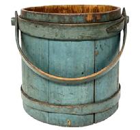 **SOLD** M166 Very early 19th century New England Wooden Firkin bearing its exceptionally beautiful original dry blue painted surface. A small note taped inside reads: �Firkin � Purchased at Sturbridge Antiques Charlton Rd. Sturbridge, Mass. April 20,1969�. The staved sides are tongue and groove construction secured with wooden bands with overlapping fingers secured with small tacks and one band has a rosehead nail at the very tip. The steamed and bent wooden handle is secured with wooden pegs and pins and there is an early repair to a split at the very end of the handle below the peg.  Measurements: 9 &frac34;� top diameter x 11" bottom diameter x 10 &frac12;� tall (not including handle) 