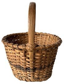 K181 Eastern Shore, Maryland hand woven footed Oak Splint Basket featuring tapered sides resting on single wrapped, steamed and bent footed base. The tall, sturdy, steamed and bent handle is woven into the sides and is secured with tiny tacks into the single wrapped, double rim that matches the footed base. Great natural patina surface with a decorative band of darker woven splints encircling the center of the sides and in the center of the bottom. Measurements: 10 &frac34;� x 11 &frac12;� diameter across top x 7� tall sides x ~13� tall with handle. The footed base is ~8 &frac14;� diameter.   