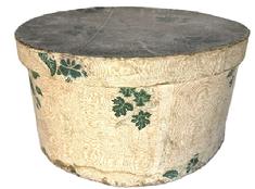 M181 Large, round early 19th century Pennsylvania wallpaper Hat Box / Bandbox. The pasteboard box is covered on the exterior with wallpaper bearing leaves and botanical motifs on an ecru and salmon color patterned background. Interior is covered with several Harrisburg, Pennsylvania newspapers dated 1837. The bottom is covered with newspapers dated 1836 and 1837. Measurements: 15 &frac34;� top diameter x 8 &frac14;� tall.