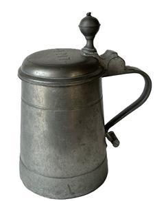 K153 Early 19th century pewter tankard with round knob finial and owner�s initials, �I.M.T.�, decoratively engraved on top of the hinged lid. Stamped inside lid with double hallmarks.  Heavy, cylindrical style body with sturdy handle. Great patina and wear indicative of use, including a few tiny holes along an interior line of corrosion to the metal. Measures 7 &frac14;� inches tall with a 4 3/8� diameter base. 