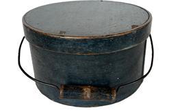 K1737 19th century New England Bail Handle Pantry Box with the original dry indigo blue painted surface. The overlapping bentwood sides are secured with small metal tacks. The sides of the Box are fitted with a pair of oval stamped tin handle mounts. Fitted with an arched wire swing handle with wooden hand grip bearing remnants of the original indigo blue paint. Natural patina interior. Measurements: 9 &frac34;� top diameter x 5 &frac14;� tall. 