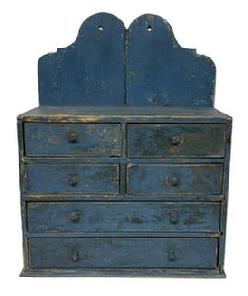 **SOLD** M240 19th century New England six (6) drawer Apothecary with old blue over the original blue painted surface featuring a tall shaped cut out back and unusual drawer configuration. The drawers are dovetailed with beaded edges surrounding the fronts. The drawer stretchers are mortised into the case. Square head nail construction. Circa 1820. Measurements: 19 &frac34;� wide x 9� deep (bottom) x 8 5/8� deep (case) x 26 1/8� tall (back) x 16 &frac14;� tall (front).  