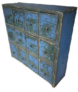 K1731 Twelve drawer 19th century Apothecary bearing vivid old blue over original green painted surface featuring three rows of drawers with mortised stretchers. The bottom row of drawers if slightly larger than the top two rows. Each of the drawers has shaped sides and original pale-yellow painted interiors. Found in Pennsylvania. Pine with small wire nail construction. Great size � versatile enough that it can sit atop a flat surface or be hung on the wall.   Measurements: 18 &frac12;� wide x 5 &frac12;� deep x 18� tall.  