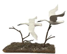 M288 Unique Folk Art carving featuring two individual, nicely detailed and hand painted, Swans in full flight. Unsigned. Mounted on branches attached to a barnacle covered piece of driftwood. The base is 18 &frac14;� long x 5� wide. Approximate overall height is 16� tall. The swans measure approximately 13 &frac12;� wide x 8 &frac34;� long and 10 &frac12;� wide x 8 &frac12;� long. 