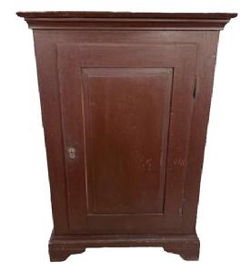 L537 Early 19th century one door cupboard with original painted surface, dovetailed case and beautiful, fully mortised raised panel door that retains its working lock with key. Applied molding surrounds the top and cupboard rests on applied bracket base with cut out feet. Clean, natural patina interior with sturdy shelves for storage. The wood is pine with square head nail construction. Of note - the back board is constructed of one wide board that has split almost exactly down the center because of age and the secure way it was nailed to the back.  Measurements: 29� wide x 18� deep x 42 &frac12;� tall. Provenance: From a private collection.   