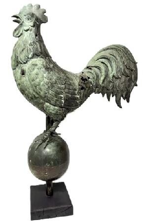 **SOLD** M221 Spectacular 19th century hollow-bodied Copper Rooster Weathervane featuring a bold Rooster perched in a crowing stance atop a large hollow bodied Ball. Exceptional details throughout � especially to the beak, face, feet and feathers. Hand crafted from molded copper, featuring a verdigris patina caused by long term exposure to the elements and evidence of being shot at in several areas.  Mounted on a later wooden base for display purposes. Approximate measurements: ~22� long x ~6 &frac12;� wide x ~35� overall height. Base measures 7 &frac14;� x 8�.  
